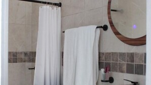 Ein Badezimmer mit Toilette, Waschbecken und Duschbereich.