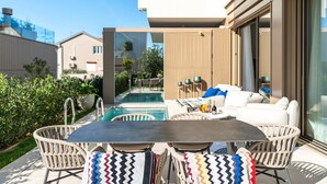 An outdoor patio with a pool, wicker furniture, and a dining table. - Beautiful home in Turanj (Turanj)