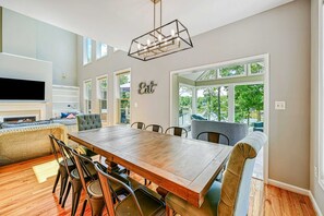 A dining area with a wooden table, chairs, and a built-in TV. - Lakefront Lake Anna, Dock, Views, Deck, Movies (Mineral)