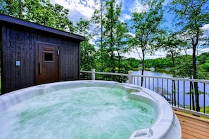 A hot tub on a wooden deck with a view of a lake and trees. - Lakefront Lake Anna, Dock, Views, Deck, Movies (Mineral)