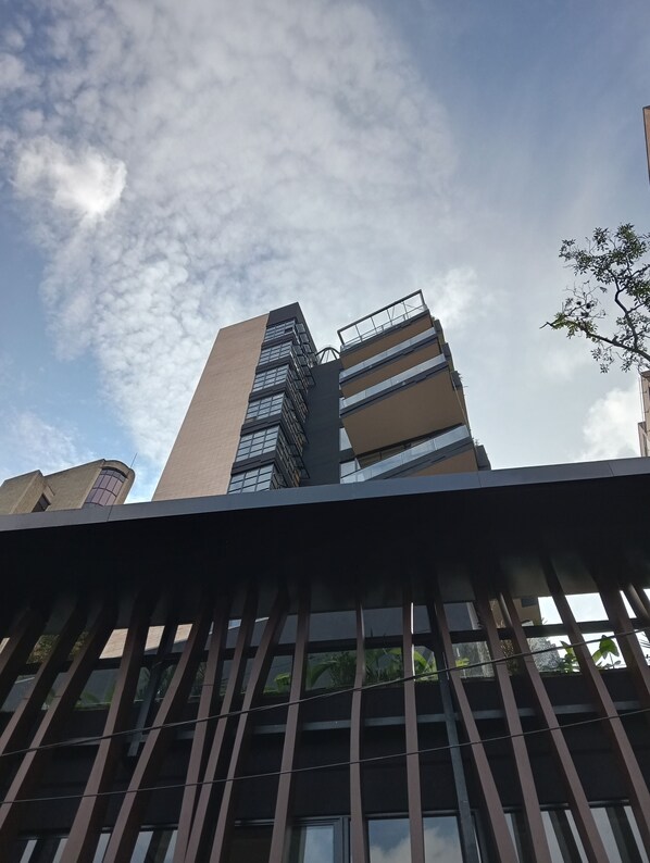 A modern building with a mix of glass and brick facades, featuring multiple balconies and a prominent corner structure. - Hotel Rulay Medellin (Medellín)