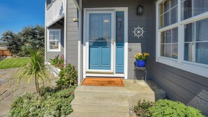 A house with a blue door, a welcome mat, and a small garden with various plants. - Gorgeous Half Moon Bay Home (El Granada)