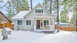 A two-story house with a covered porch and a snow-covered front yard. - Boulder Bay Bungalow (Big Bear Lake)