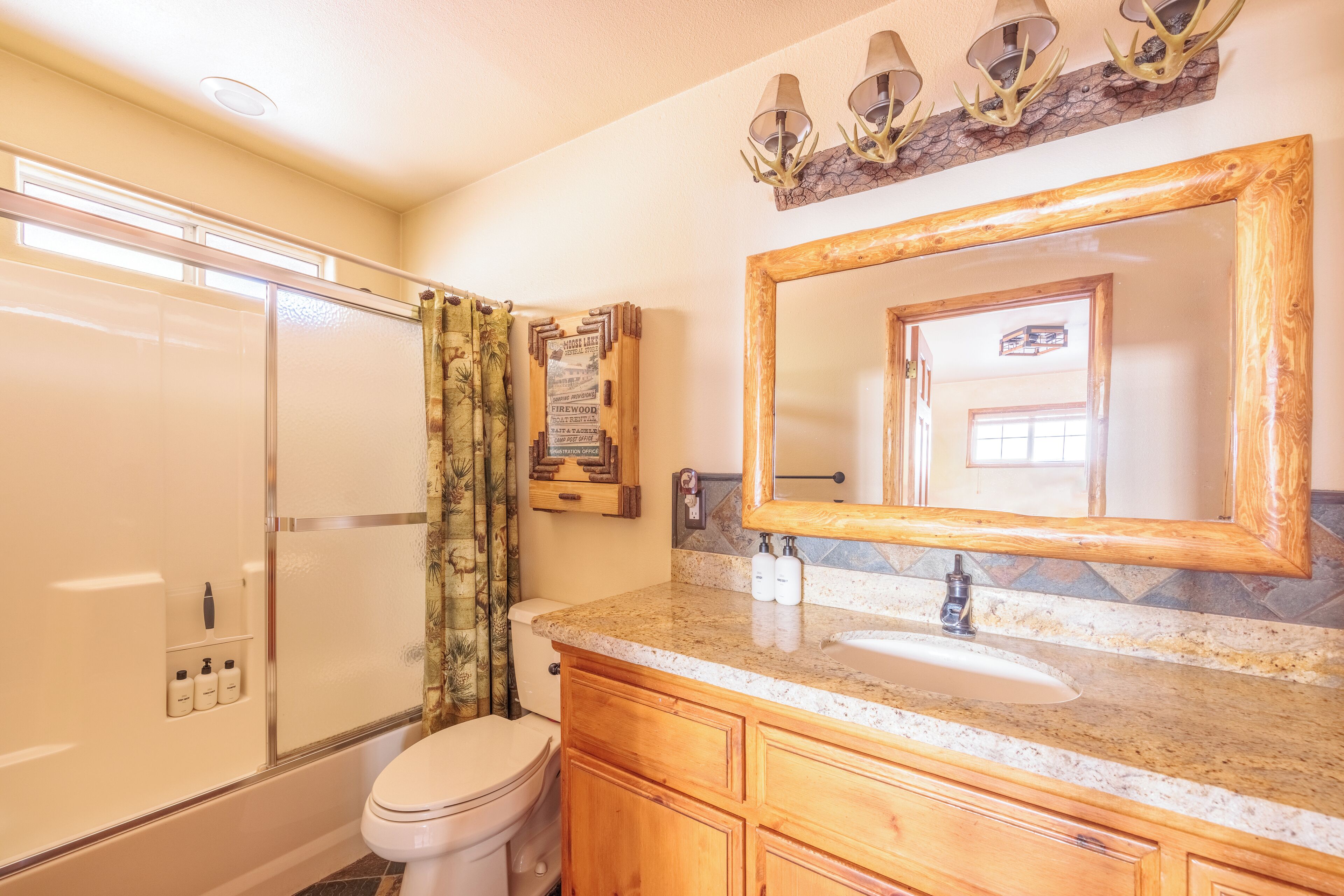 Un bagno con doccia, toilette, lavabo e uno specchio grande.