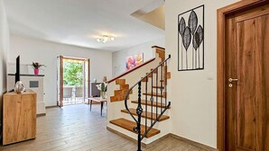 A spacious living area with a wooden staircase, a door with a window, and a view of the outdoors. - Beautiful home in Novigrad with WiFi (Novigrad)
