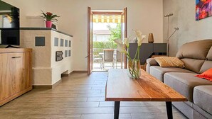 A modern living room with a wooden coffee table, a grey sofa, and a TV on a cabinet. - Beautiful home in Novigrad with WiFi (Novigrad)