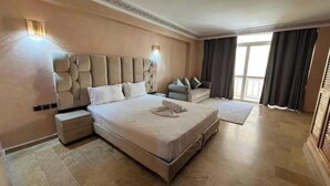 A large bed with a headboard, bedside tables, and a nightstand. - Duplex in City Center - Patio & Parking (Marrakesh)