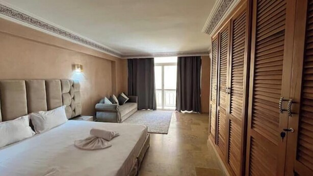 A hotel room with a large bed, a smaller bed, a sofa, and a wardrobe. - Duplex in City Center - Patio & Parking (Marrakesh)
