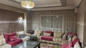 A living room with a sofa set, a coffee table, and a chandelier. - Duplex in City Center - Patio & Parking (Marrakesh)