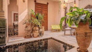 A traditional interior with a pool, ornate doors, and potted plants. - Riad MAYAN : Heated Pool & GYM (Marrakesh)