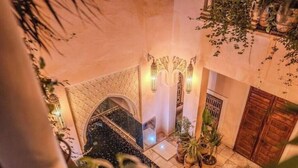 A spacious indoor area with a fountain, potted plants, and a traditional archway. - Riad MAYAN : Heated Pool & GYM (Marrakesh)