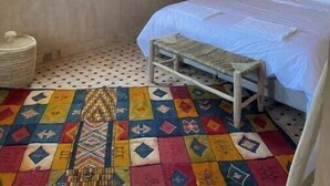 A room with a bed, a window, a hanging light fixture, and a patterned floor. - Skoura Ranch - Palmeraie (Skoura)