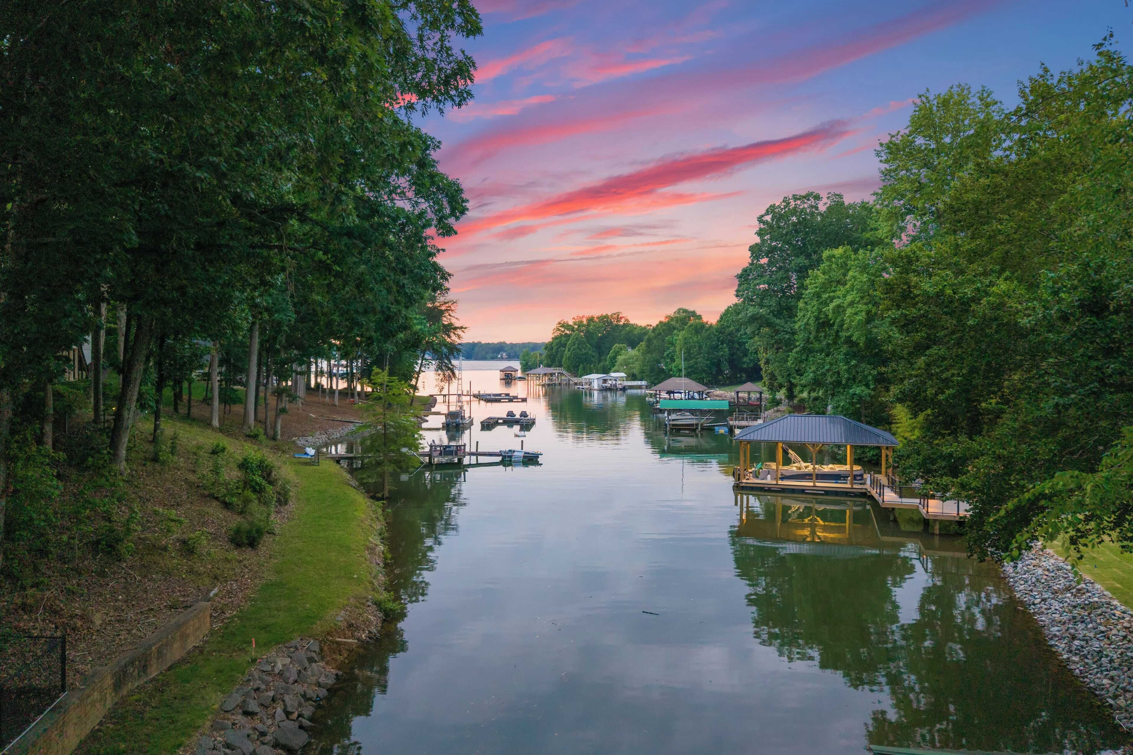 A calm river with boats, a gazebo, and a dock.
