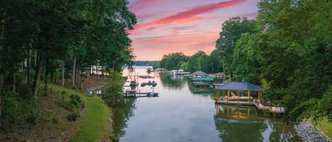 A calm river with boats, a gazebo, and a dock.