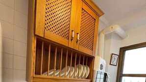 A kitchen with wooden cabinets, a granite countertop, a stainless steel sink, and a window.
