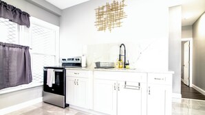 A modern kitchen with white cabinets, a stainless steel oven, and a marble backsplash. - Modern 1Br 1Ba Apartment Close Falls And Casino (Niagara Falls)