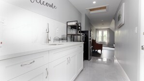 A modern kitchen with white cabinetry, a built-in oven, and a countertop with a sink.