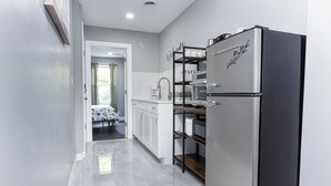 A modern kitchen with a stainless steel refrigerator, white cabinets, and a built-in oven.