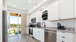 A modern kitchen with white cabinetry, stainless steel appliances, and a view to the outside. - 3 Bed Brand NEW Townhome in Downtown Grand Junction! NO EXTRA FEES! (Grand Junction)