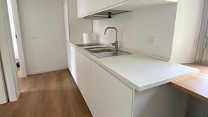 A modern kitchen with white cabinetry, a stainless steel sink, and a wooden countertop. - Cris al Pigneto is a B&B Comfortable, bright and well connected to the center. (Roma)