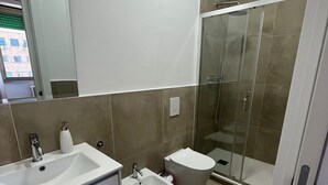 A modern bathroom with a large sink, bidet, and glass shower enclosure. - Cris al Pigneto is a B&B Comfortable, bright and well connected to the center. (Roma)