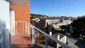 Ein Balkon mit Blick auf ein Wohngebiet, einschließlich Gebäude und einem klaren Himmel.