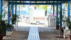 A covered wooden deck with a truck labeled 'SWEETLAND' parked outside. - Las Palmas Cabins (Dixon Cove)