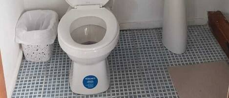 Un baño con inodoro, lavamanos y espejo.