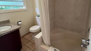 Un baño con bañera, inodoro y lavabo.