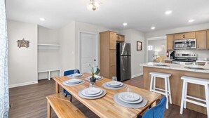 A modern kitchen with wooden cabinets, a stainless steel refrigerator, and a built-in microwave.