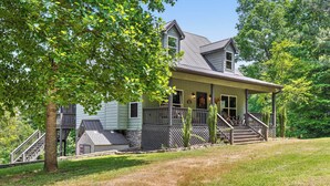 A two-story house with a porch, a staircase, and a small shed. - Updated Cabin - Hiwassee Highlife (Decatur)