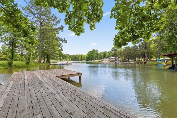 A wooden dock extending into a calm lake surrounded by lush greenery and trees. - Updated Cabin - Hiwassee Highlife (Decatur)