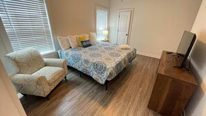A bedroom with a bed, a chair, a desk, and a ceiling fan. - Near Downtown, Dining & Base - Beach Flow Bungalow (Pensacola)