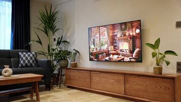 A living room with a sofa, coffee table, and a large painting of a cozy interior scene.