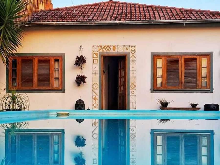 A building with a swimming pool, a tiled roof, and a doorway.