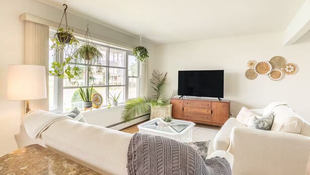 Ein Wohnzimmer mit einer Couch, einem Couchtisch, einem Fernseher und einer Holzkabine.