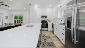 Una cocina moderna con armarios blancos, electrodomésticos de acero inoxidable y una isla grande.