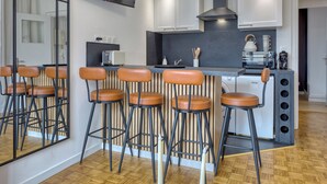 Una cucina moderna con un'area bar, una lavatrice e un grande specchio.