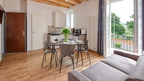 Cocina moderna con zona de comedor, piso de madera y vistas al exterior.