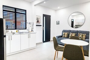 Eine moderne Küche mit weißen Schränken und einem Fenster in Schwarz.