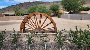 A large wooden water wheel in a desert setting with a clear sky. - Charming 2BD / 1 BA farmhouse on 2.5 acres w/mountain views in fabulous Glendale (Glendale)
