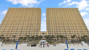 Un hotel grande con varios pisos y balcones, una cancha de voleibol de playa y palmeras.
