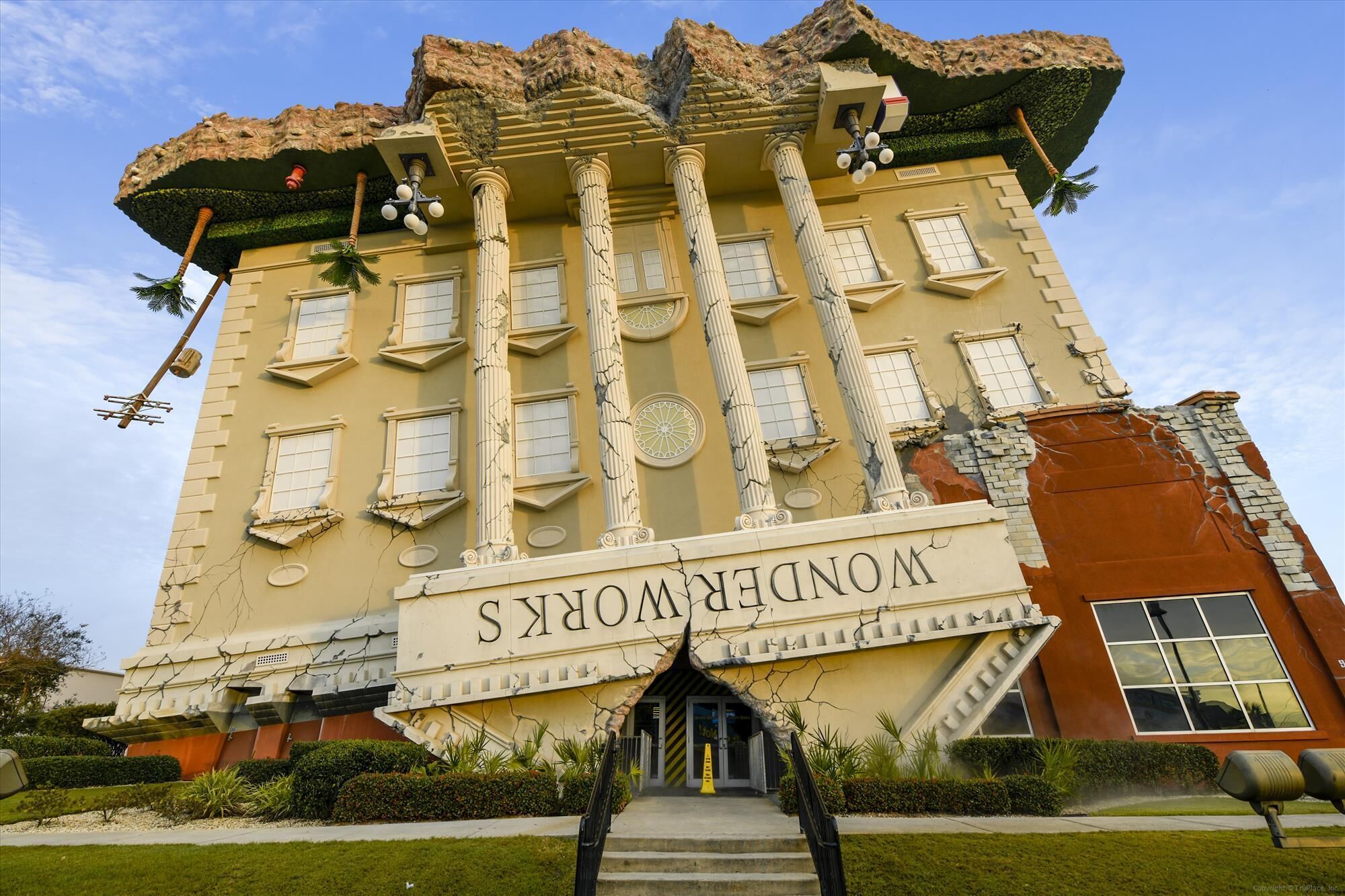 Un edificio con un gran letrero que dice "WONDERWORKS". Cuenta con columnas, una escalera y un diseño arquitectónico único.