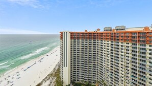 Ein Hochhaus-Hotel mit mehreren Balkonen mit Blick auf einen Strand.