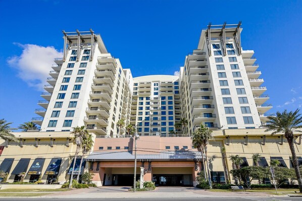 A modern hotel with a central atrium, multiple floors, and a flat roof.