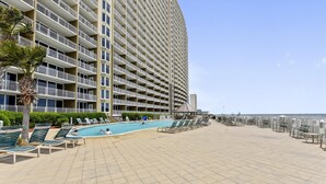 Un hôtel doté d’une grande piscine, de nombreux balcons et offrant une vue sur l’océan.