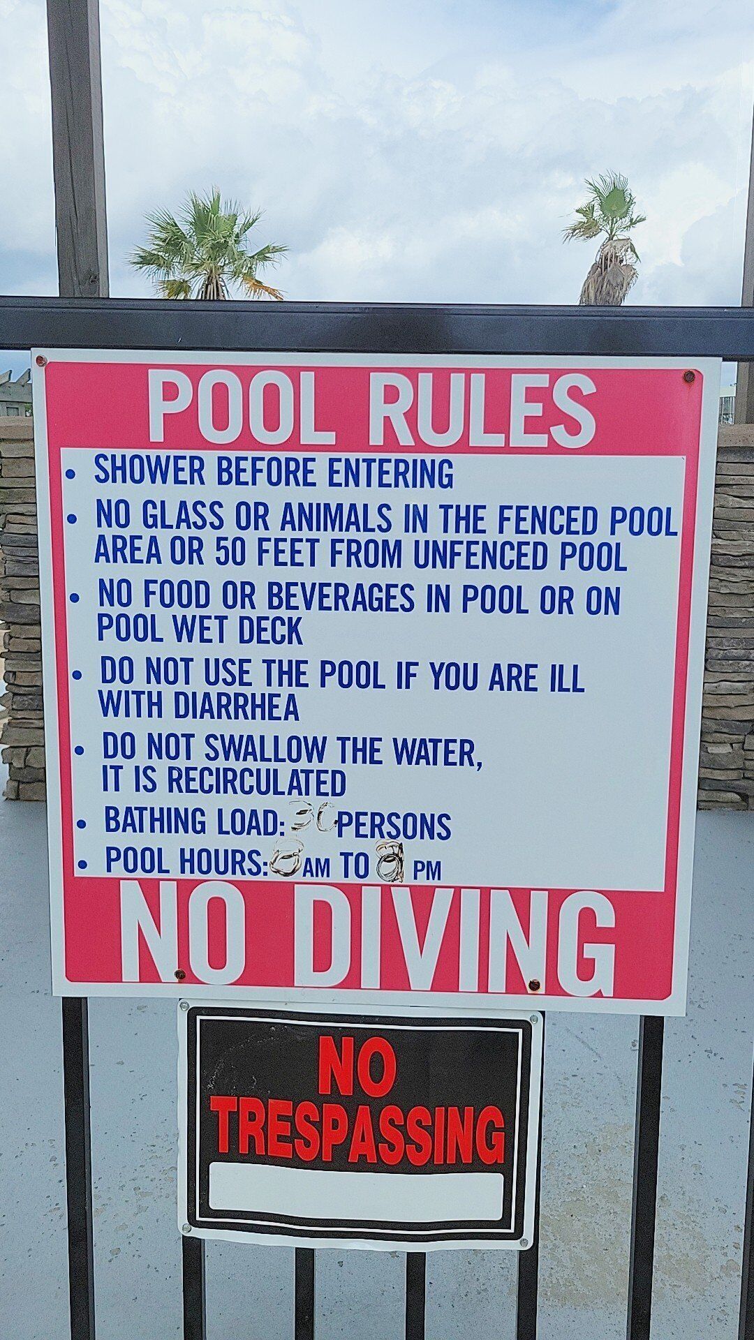 Segnaletica con le regole della piscina e l'avviso 'NO DIVING'.