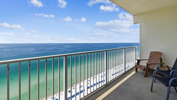 A balcony with a view of the ocean and beach.