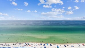 A beach with clear turquoise waters and a sandy shore.