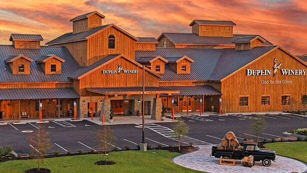 A wooden building with the name "Dupin Winery" and a slogan "God be the Glory".